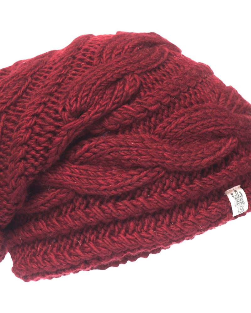 Back of a model wearing a size one-size-fits-all Triple Braid Cable Slouch Hat In Burgundy in Burgundy by Nirvanna Designs. | dia_product_style_image_id:355979